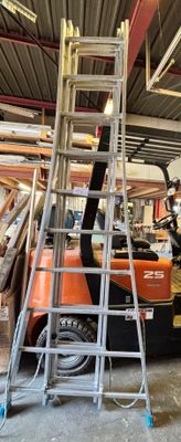 une photo d'un chariot élévateur dans un entrepôt, avec une échelle