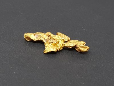 a close up of a piece of gold on a black surface