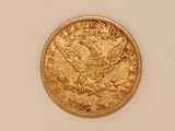 a close up of a gold coin on a white surface