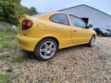 a picture of a yellow car parked in front of a building