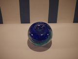 a blue glass ball sitting on a white table