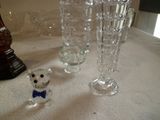 Plusieurs vases en verre et une figurine d'ours sont posés sur une table