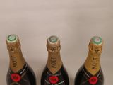 three bottles of champagne are lined up on a white surface