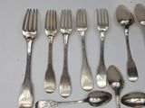 a lot of silver spoons and forks on the table