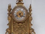 a gold clock sitting on top of a white table