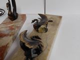 three statues of animals on a marble block