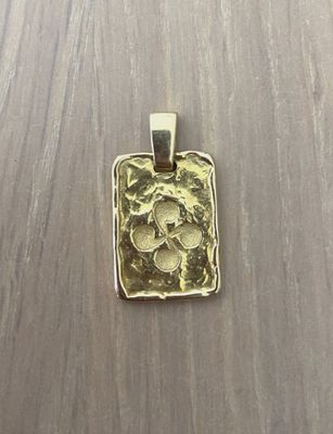 a picture of a gold pendant with a skull on it