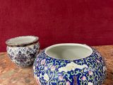 deux vases posés sur une table, avec un mur rouge en arrière-plan