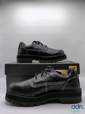 chaussures en cuir noires pour homme, avec des lacets noirs, présentées dans une boîte