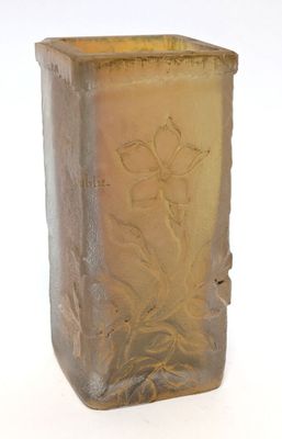a glass vase that has a flower etched on it