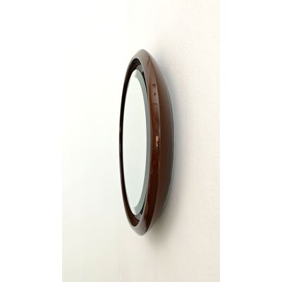 un miroir accroché au mur, à côté d'un mur blanc