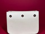 a white purse sitting on top of a red surface