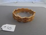 a gold bracelet on a bed with a price tag on it