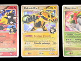 Trois cartes Pokémon sont représentées en rangée sur un fond noir