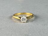 a yellow gold engagement ring with a single diamond