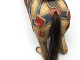 an old wooden toy horse with a long mane and a saddle
