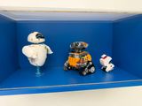deux robots posés sur une étagère bleue avec une petite voiture