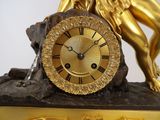 a statue of a woman holding a clock on a rock