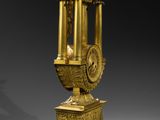 a gold clock that is sitting on a pedestal