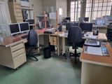 a desk with two computers and a chair in a room