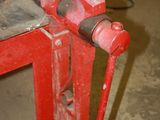 a red vise on a workbench in a garage