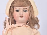 a doll that is wearing a dress and a hat