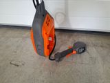 an orange and black vacuum cleaner sitting on the ground next to a garage door