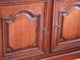 a wooden cabinet with two doors and a mirror on top of it