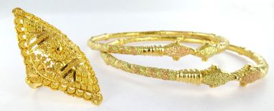 two pieces of gold colored jewelry on a white surface
