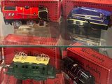 quatre trains miniatures exposés dans une vitrine