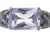 un gros plan d'une bague ornée d'une pierre violette entourée de diamants violets et blancs