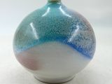 un vase bleu et blanc posé sur une surface blanche