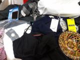 a pile of clothes and other items on a bed