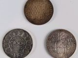 three different coins sitting on top of a white surface next to each other