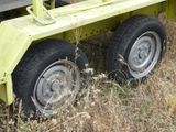 a yellow trailer that has two wheels on it in the grass