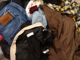 a pile of clothes sitting on top of a bed