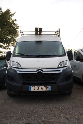 une camionnette blanche garée dans un parking à côté d'autres voitures