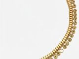 gros plan d'un collier en or sur fond blanc