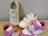 deux paires de chaussures blanches et roses sur un parquet