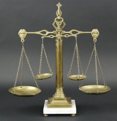 une balance ancienne en laiton comportant trois plateaux de chaque côté