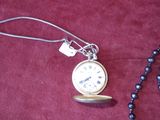 a necklace with a pocket watch on it and a bead necklace with a chain