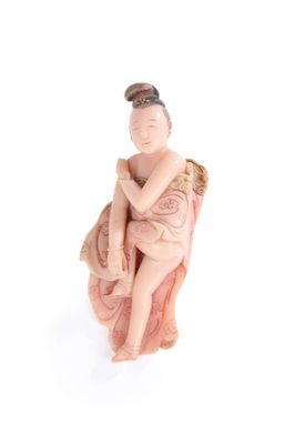 figurine représentant une femme assise sur une chaise, les bras croisés