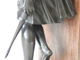 statue of a boy in a coat and hat holding a sword