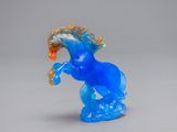 a blue glass horse that is standing on its hind legs