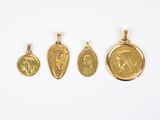 trois pendentifs en or représentant Jésus et Marie sur fond blanc