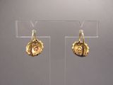 boucles d'oreilles plaquées or exposées dans une vitrine transparente