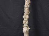 an old wooden sculpture of a person holding a knife