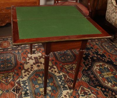 une petite table au plateau vert posée sur un tapis