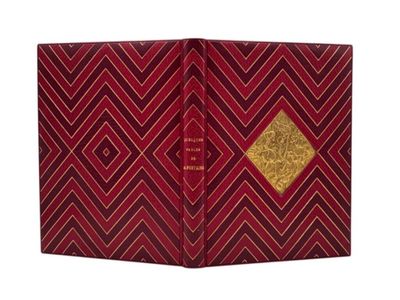 un livre rouge et doré orné d'un losange doré sur la couverture