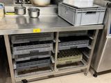 une cuisine avec un plan de travail en inox et un évier en métal